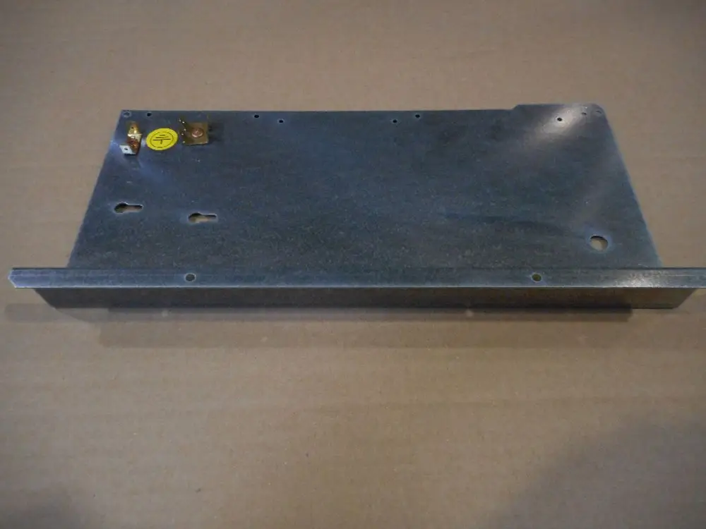 Baugruppenträger aus Metall mit verschiedenen Löchern und Anschlussklemmen, beschriftet mit einem gelben Symbol, produziert von Remeha.